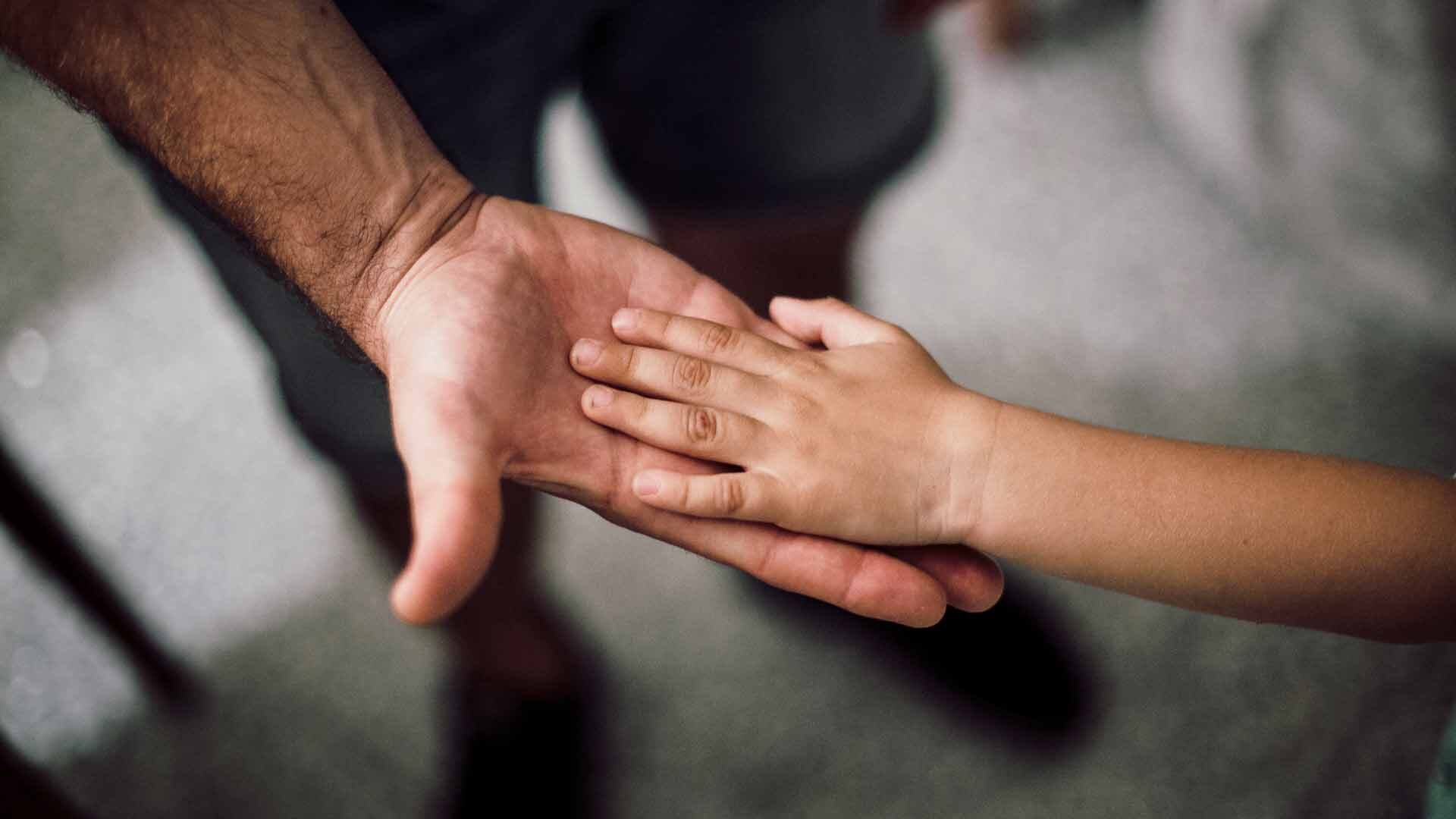man holding hands with child - High Conflict Custody Lawyer
